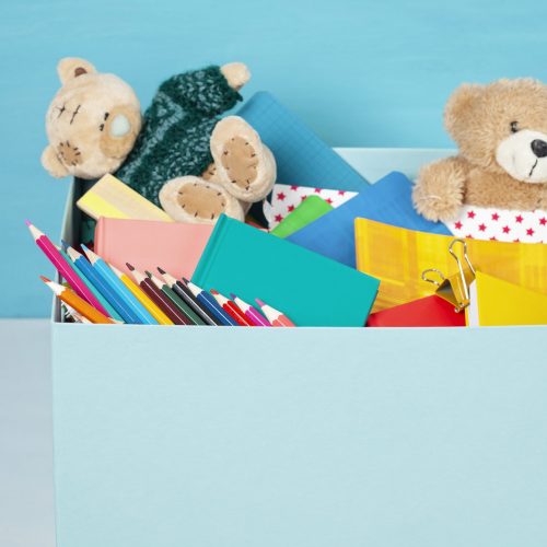 Box with donations for children with school supplies and toys, charity concept